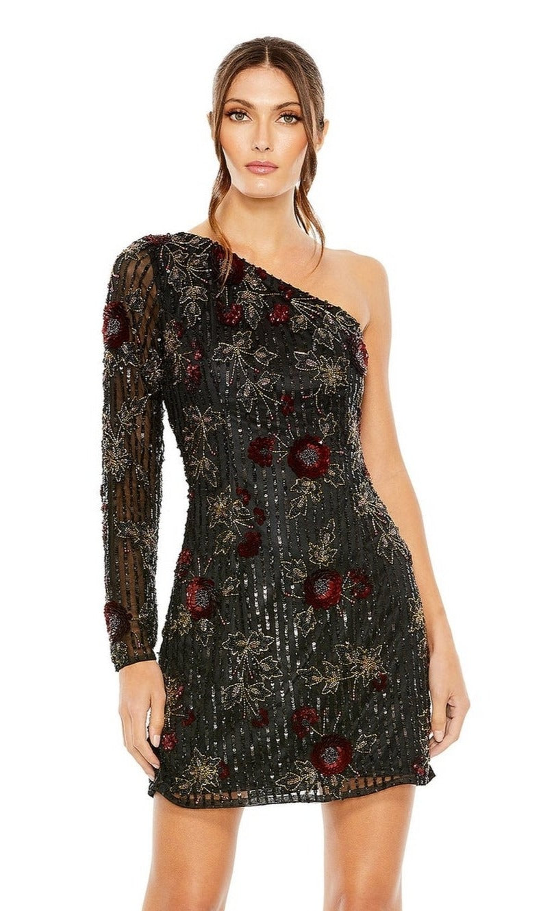 A woman stands against a white background wearing the Short Homecoming Dress 5919 by Mac Duggal, a beaded, fitted one-shoulder mini dress with a sheer long sleeve, red floral accents, and gold sequin embellishments.